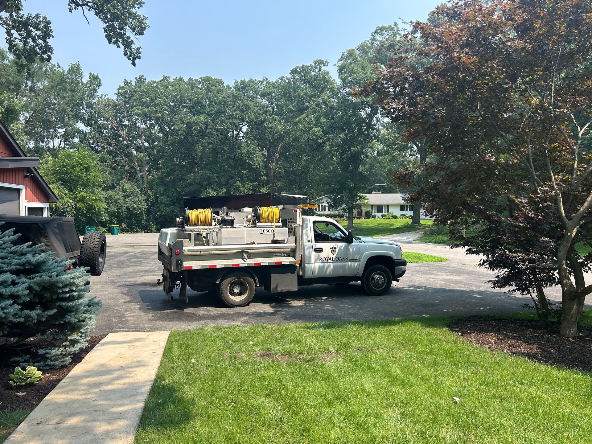 Plant health care service truck with spray system parked at residential property