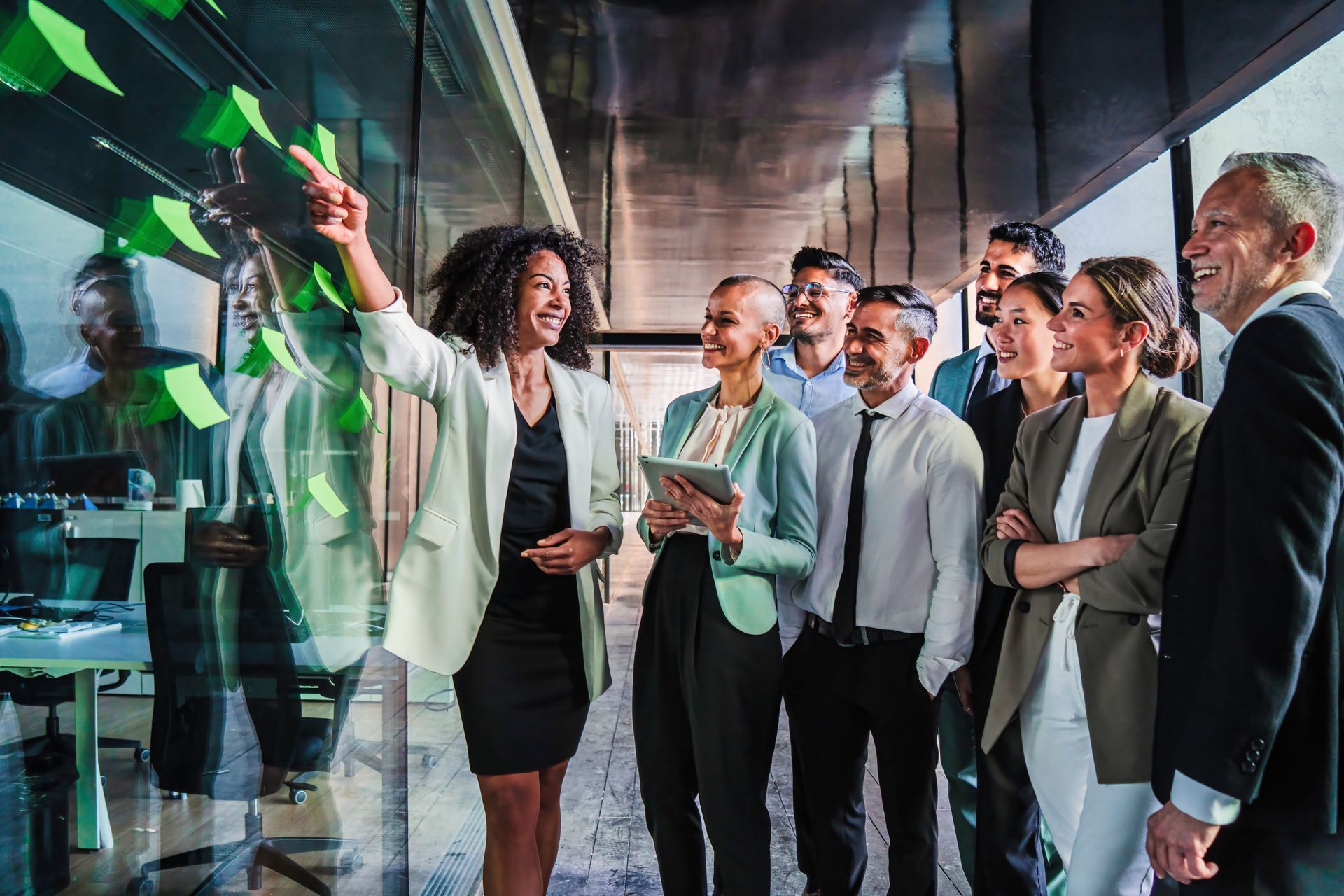 A group of coworkers celebrating in a modern office as confetti falls, with one person raising a bottle.