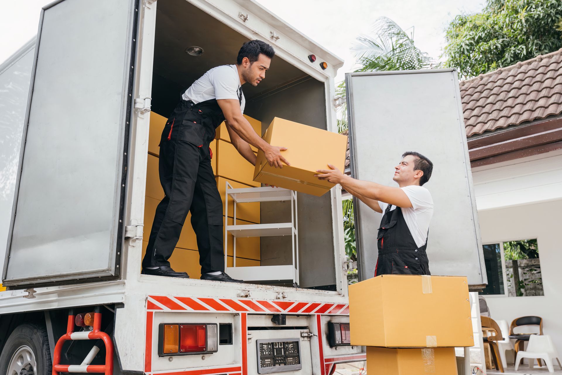 Man carrying a table up a loading ramp into a moving truck.