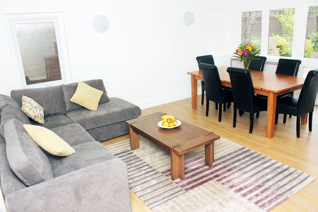 A living room with a couch , table and chairs