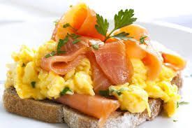 Scrambled eggs with smoked salmon on toast, garnished with parsley.