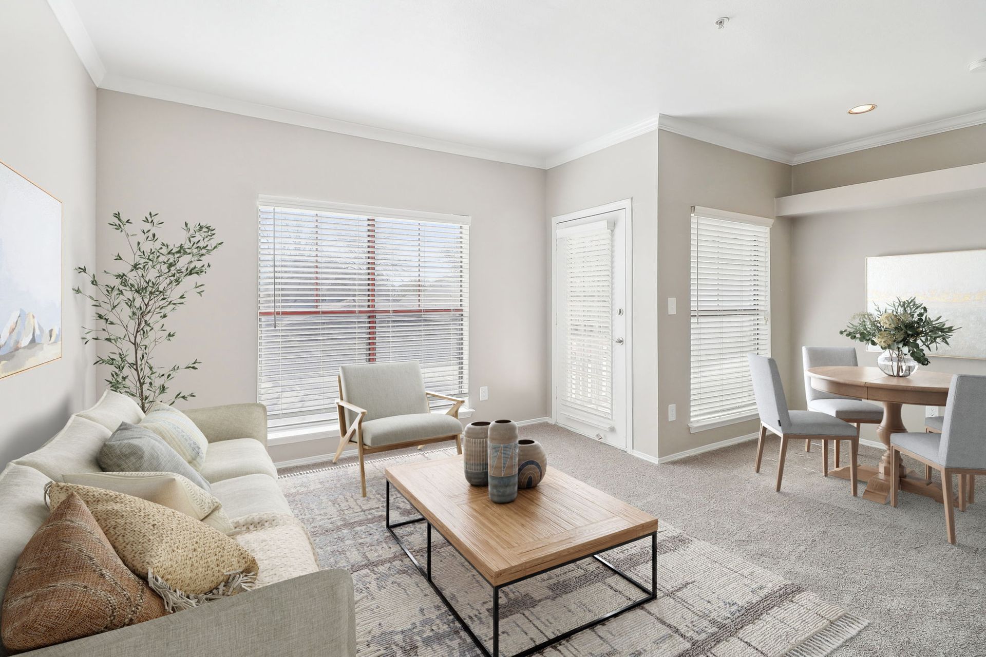 A living room with a couch , chairs , a coffee table and a dining table.