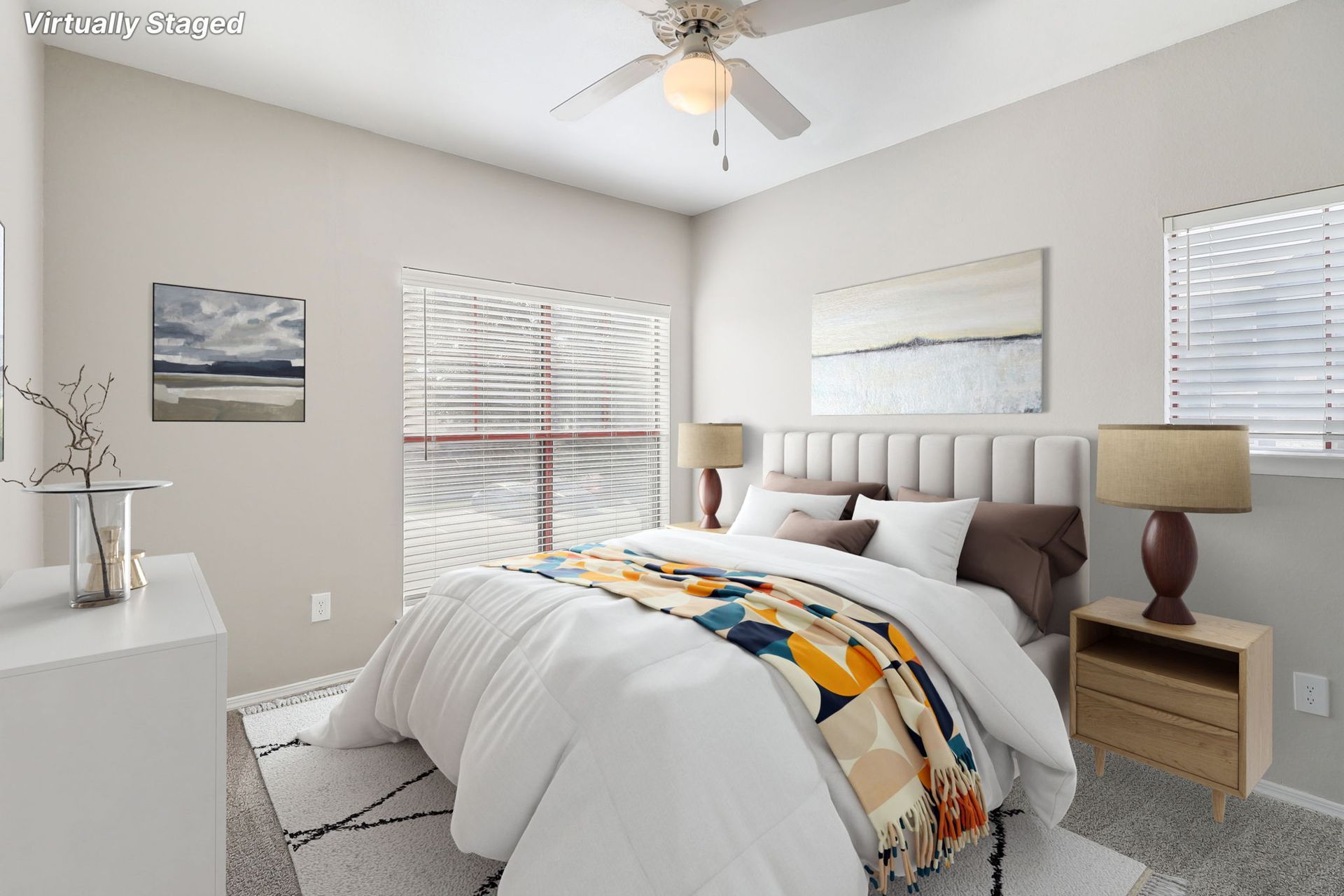 A bedroom with a large bed and a ceiling fan.