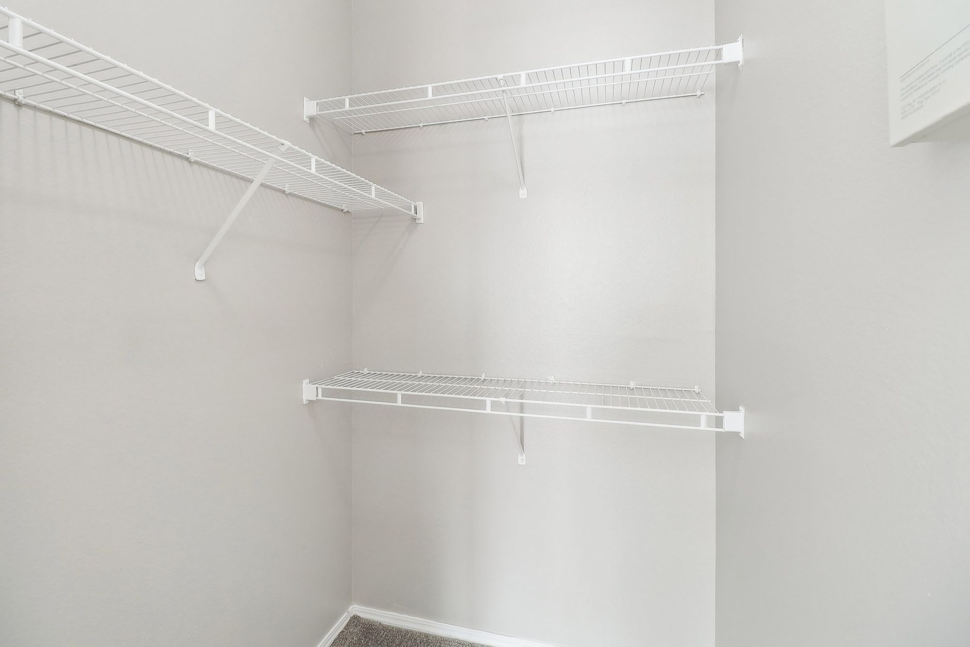 A walk in closet with lots of shelves and hooks.
