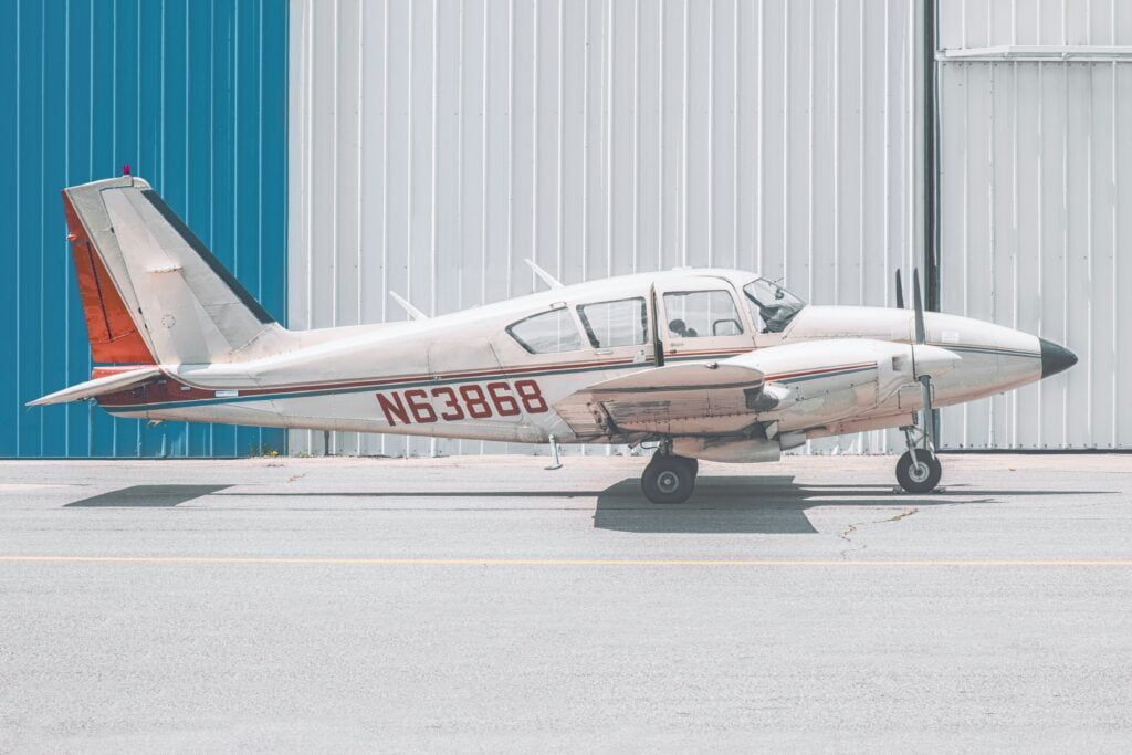 A small plane with the numbers n63868 on the side is parked in front of a building.