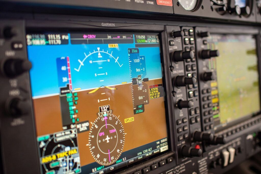 A close up of a cockpit of an airplane with a computer screen.