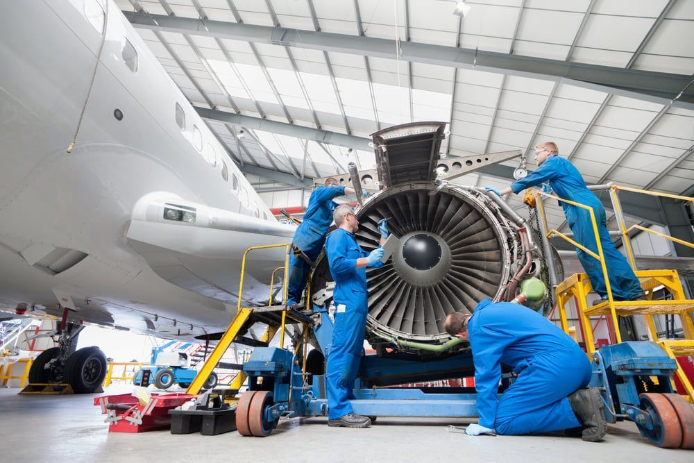 a group of mechanics working on a turbine engine.