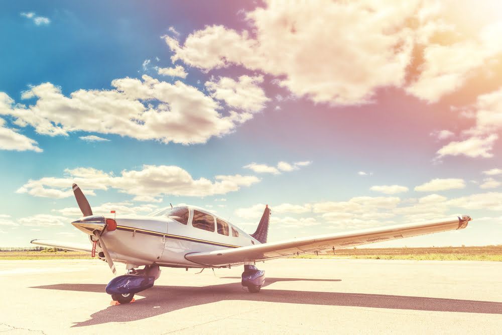 A small propeller plane is parked on a runway.