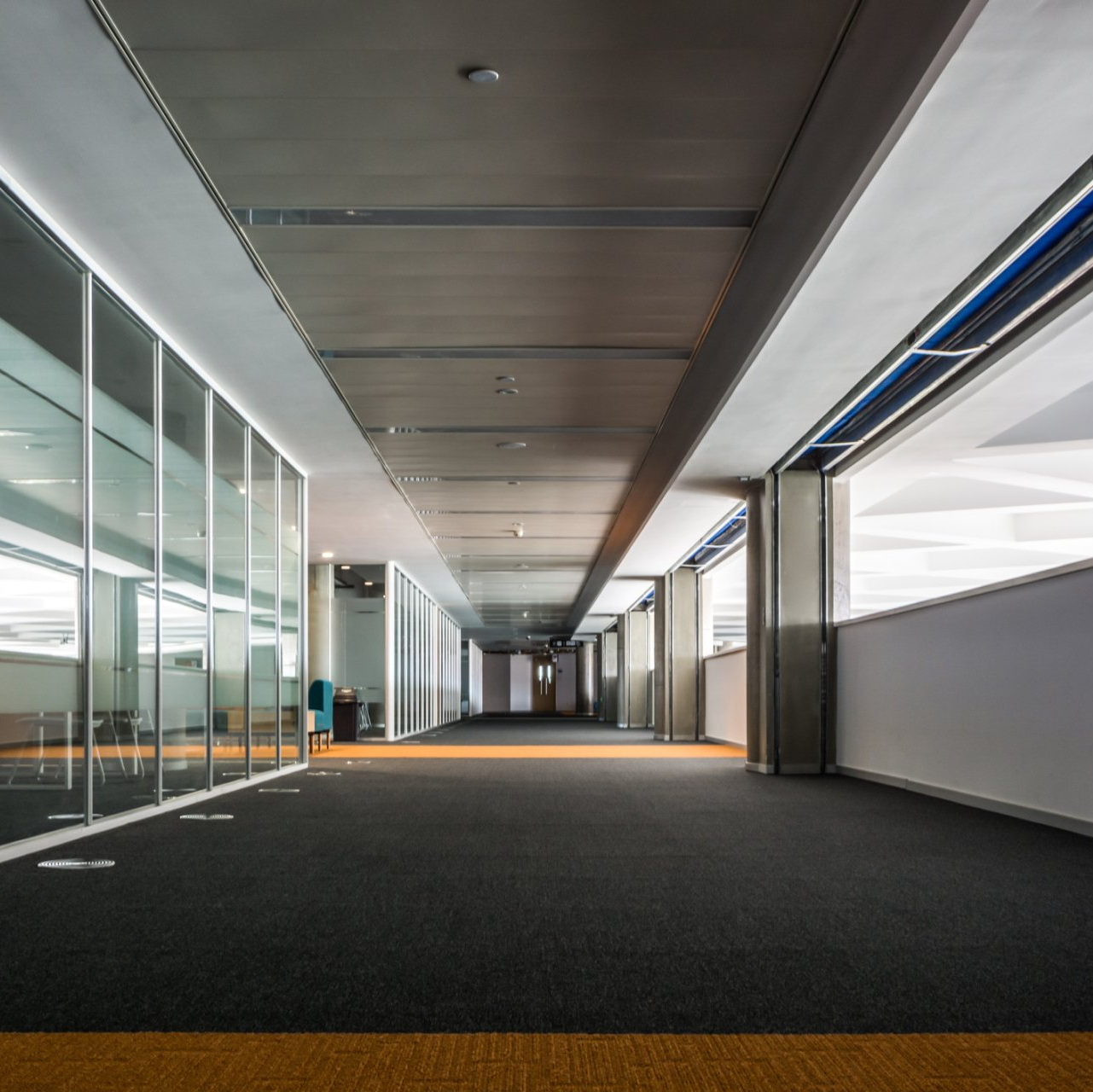 A long hallway in a building with a lot of windows