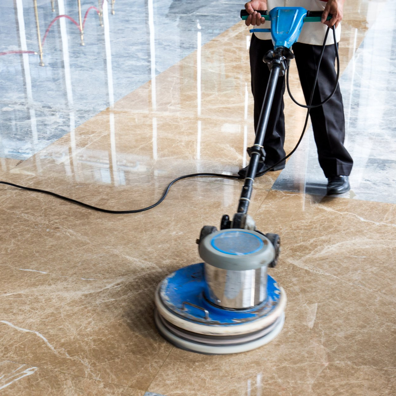 A man is using a machine to clean a marble floor.