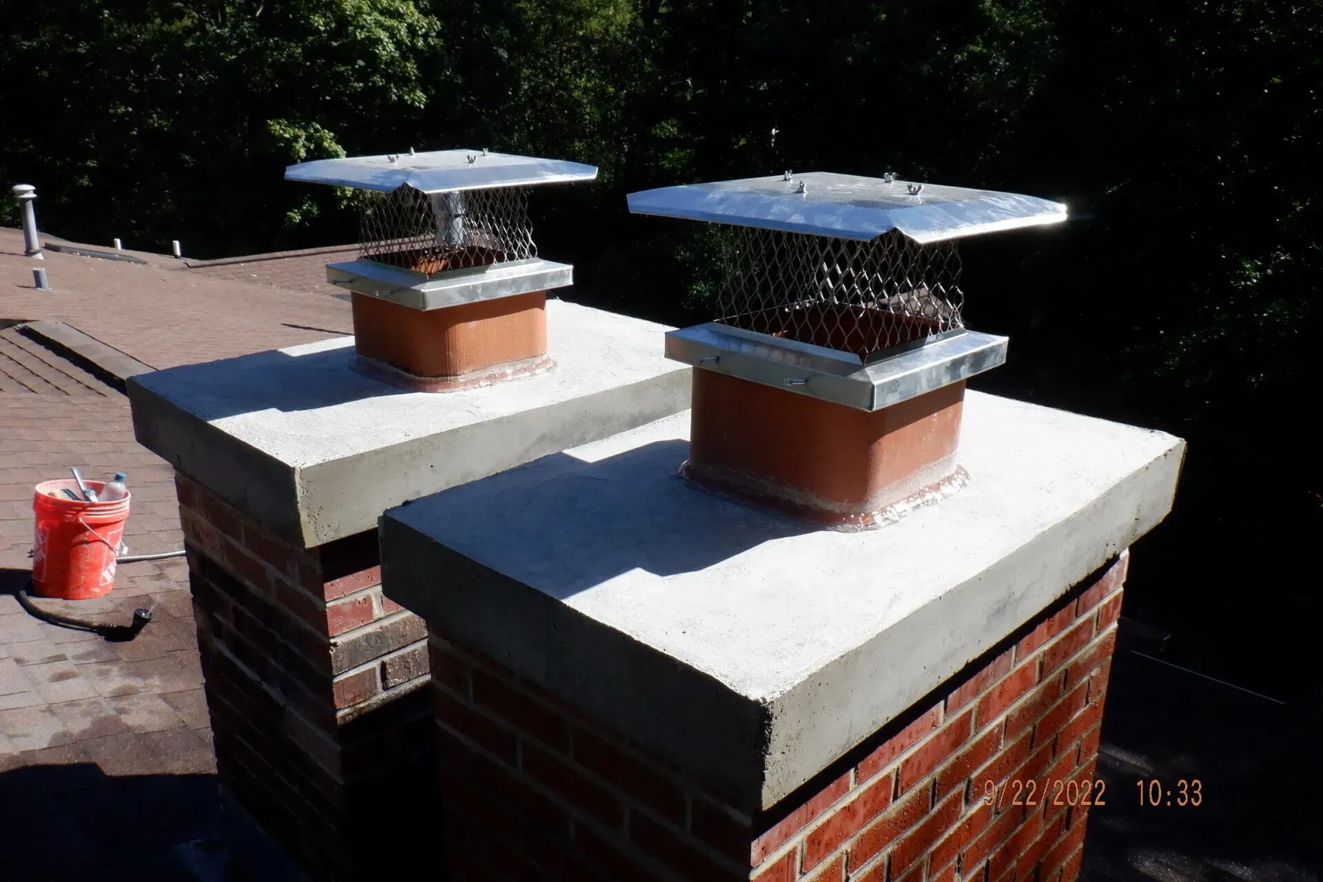 Two Chimneys Are Sitting On Top Of Concrete Pillars On A Roof - Elgin, IL - Valor Chimney Services Corporation
