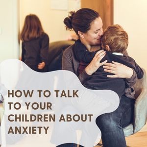 A woman is holding a child in her lap and talking to them about anxiety