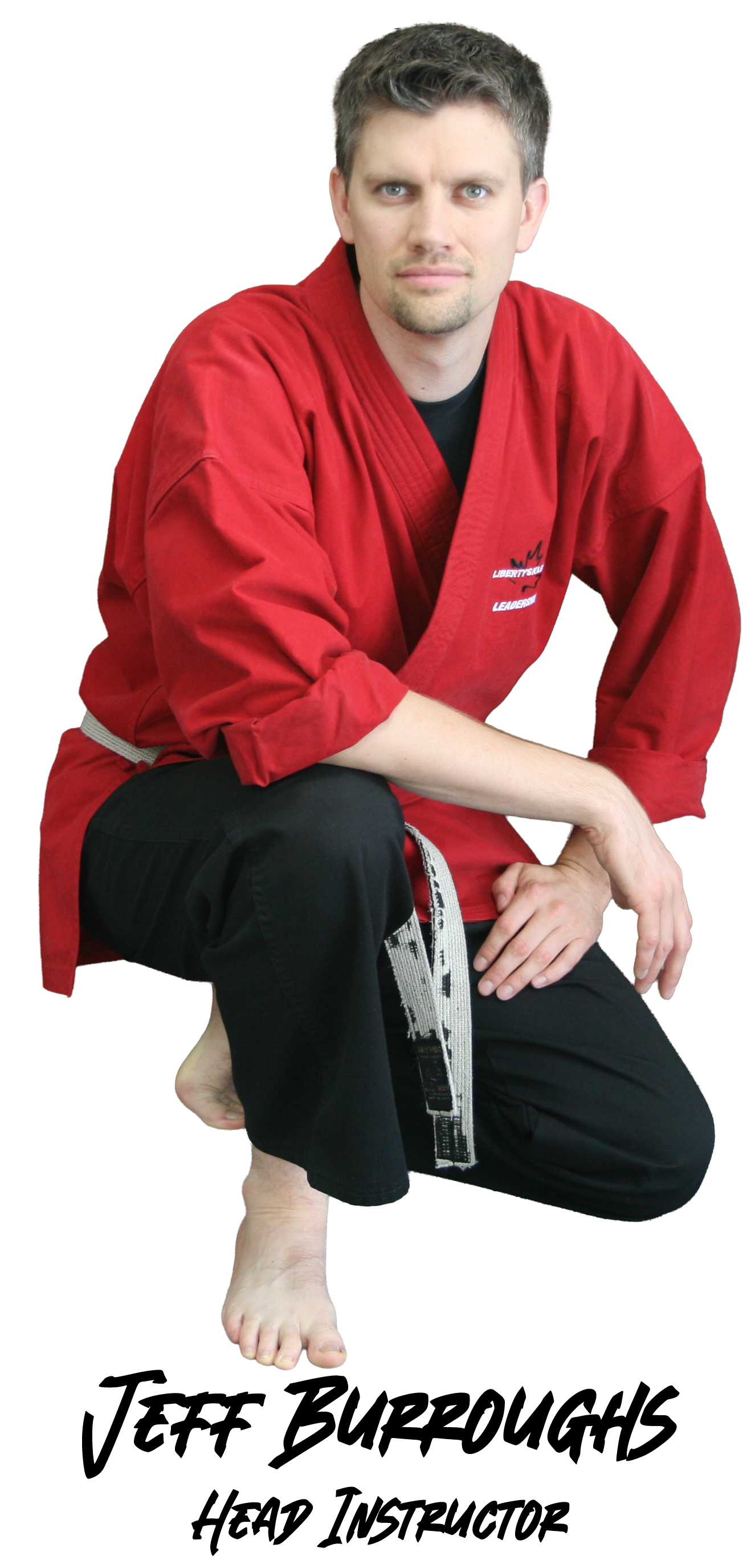 Jeff Burroughs, Head Instructor, kneeling in a red karate uniform and black pants, looking at the camera.
