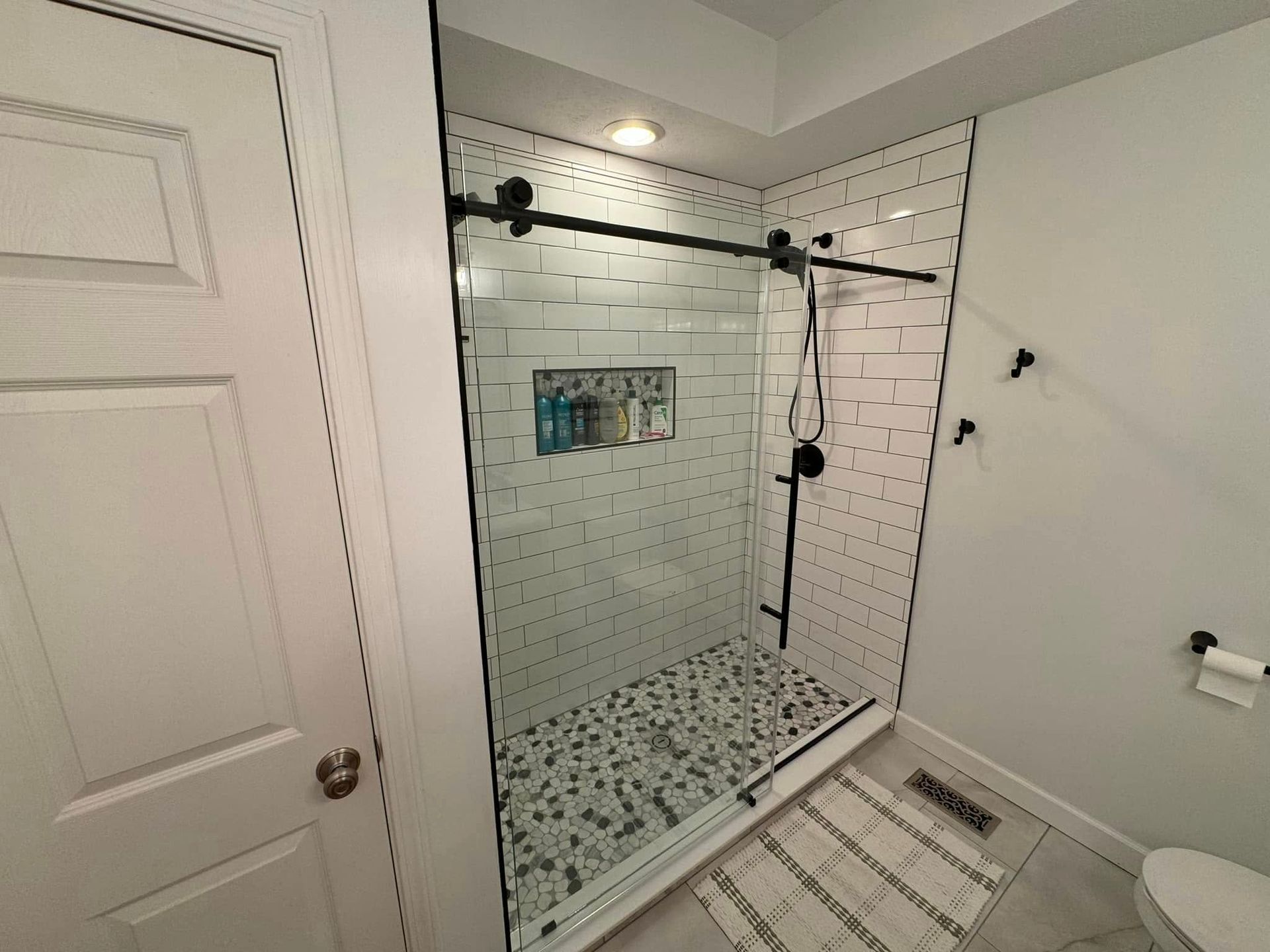 A bathroom with a sliding glass shower door and a toilet.