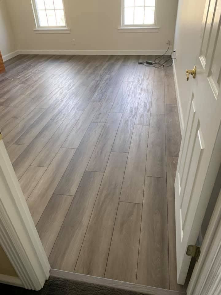 A bedroom with hardwood floors and a walk in closet filled with clothes.