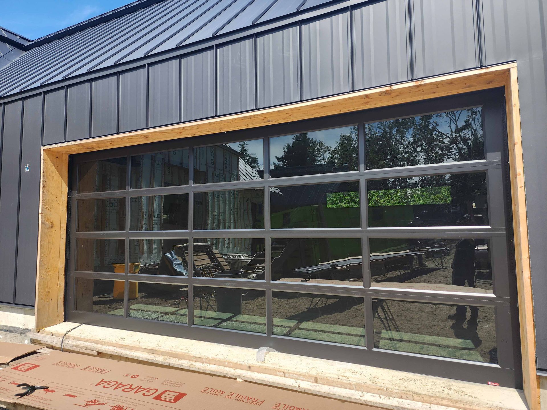 Une porte de garage est en cours d'installation sur le côté d'un bâtiment.
