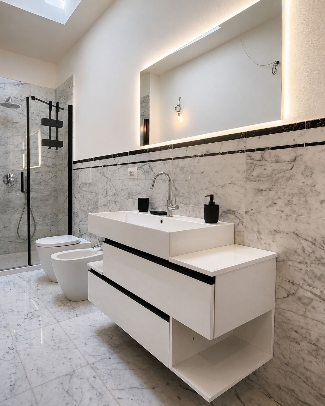 Bagno moderno bianco con mobile lavabo sospeso, ampio specchio, WC e box doccia in vetro.