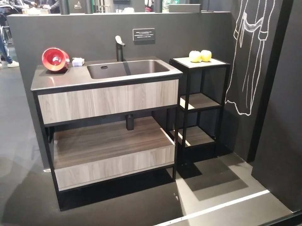 Mobile bagno moderno con lavabo nero, ante in legno e ripiano laterale nero con asciugamani e oggetti decorativi.
