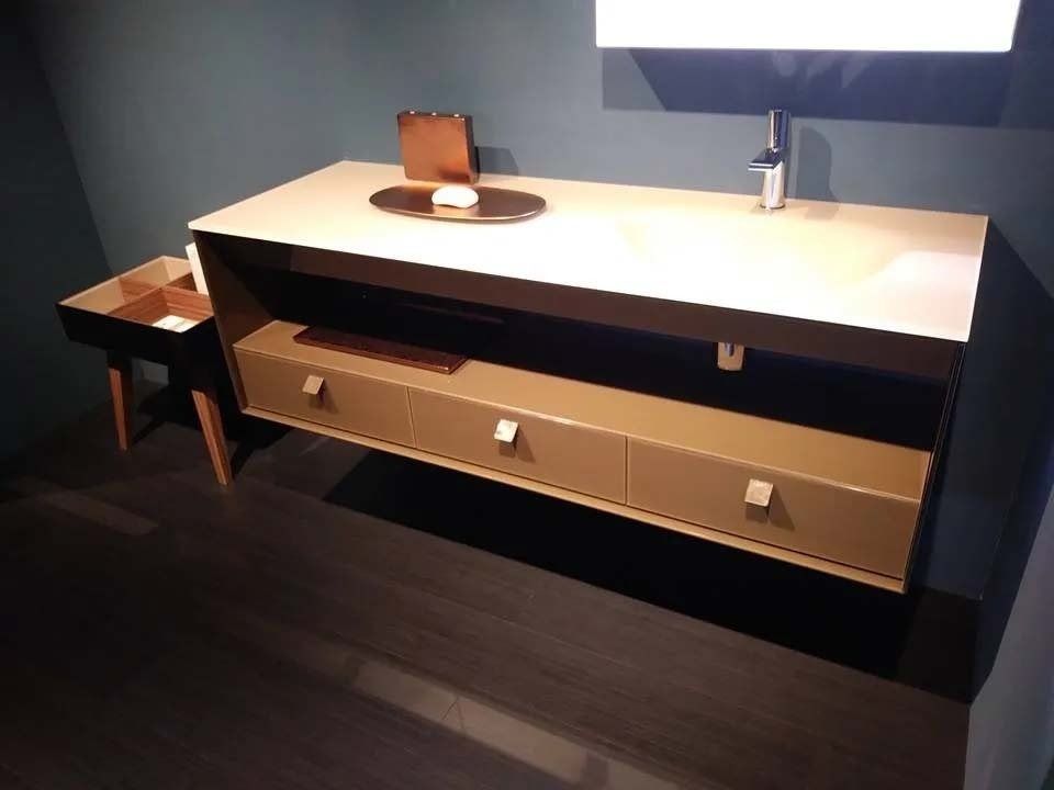 Bagno moderno con mobile lavabo bianco, grande specchio e pareti e pavimento scuri.