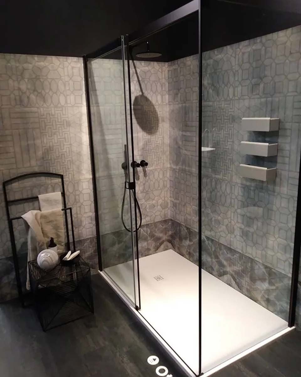 Bagno moderno con box doccia in vetro, rubinetteria nera e mensole a muro.