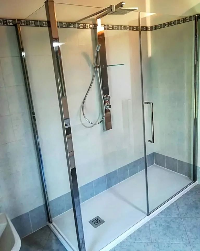 Box doccia in vetro con finiture cromate e pavimento piastrellato in un bagno