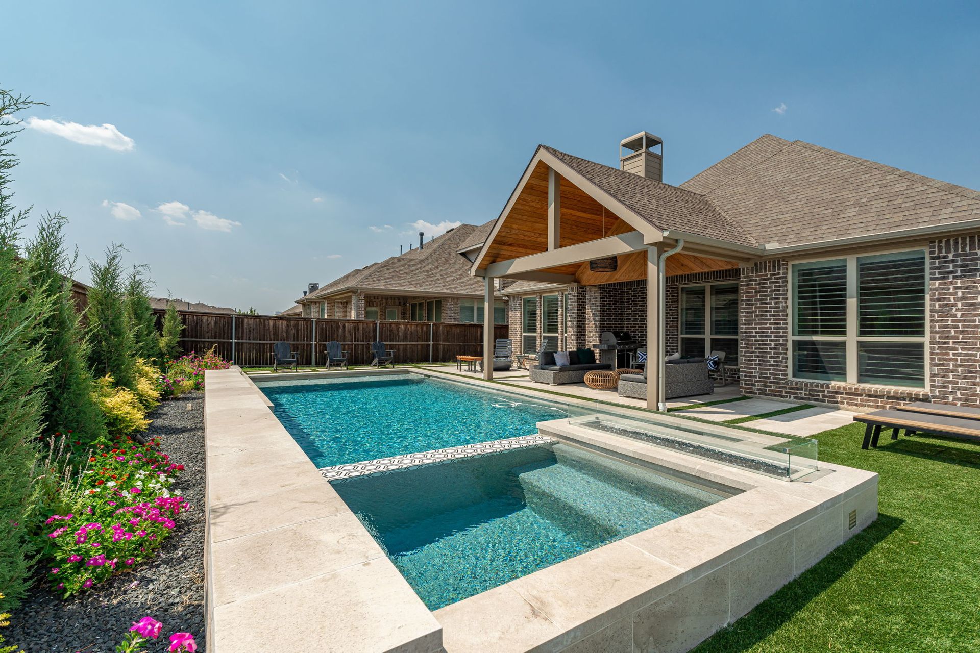 There is a large swimming pool in the backyard of a house.
