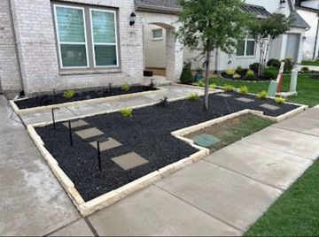 A sidewalk leading to a house with a garden in front of it.