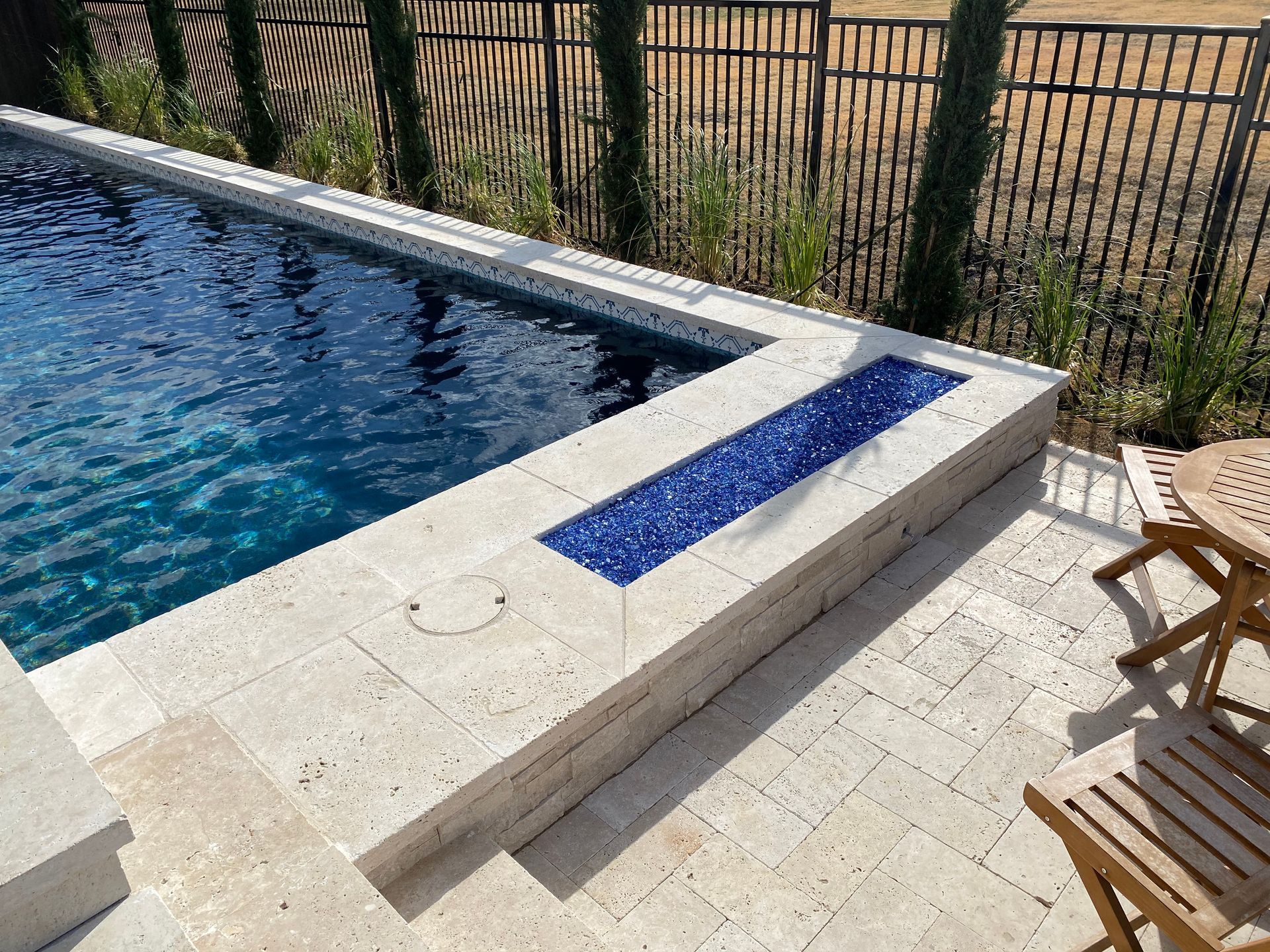 A swimming pool with a table and chairs next to it.