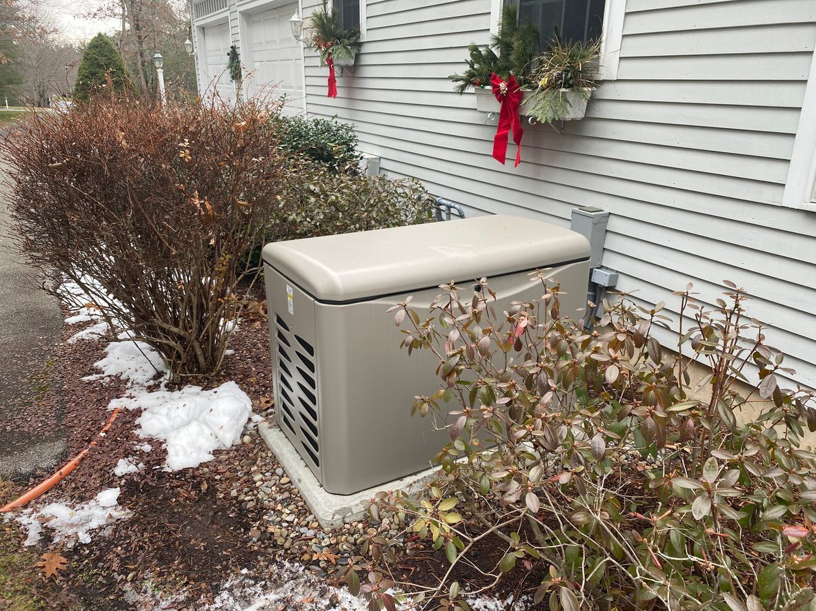 A standby generator next to a house with seasonal decorations.