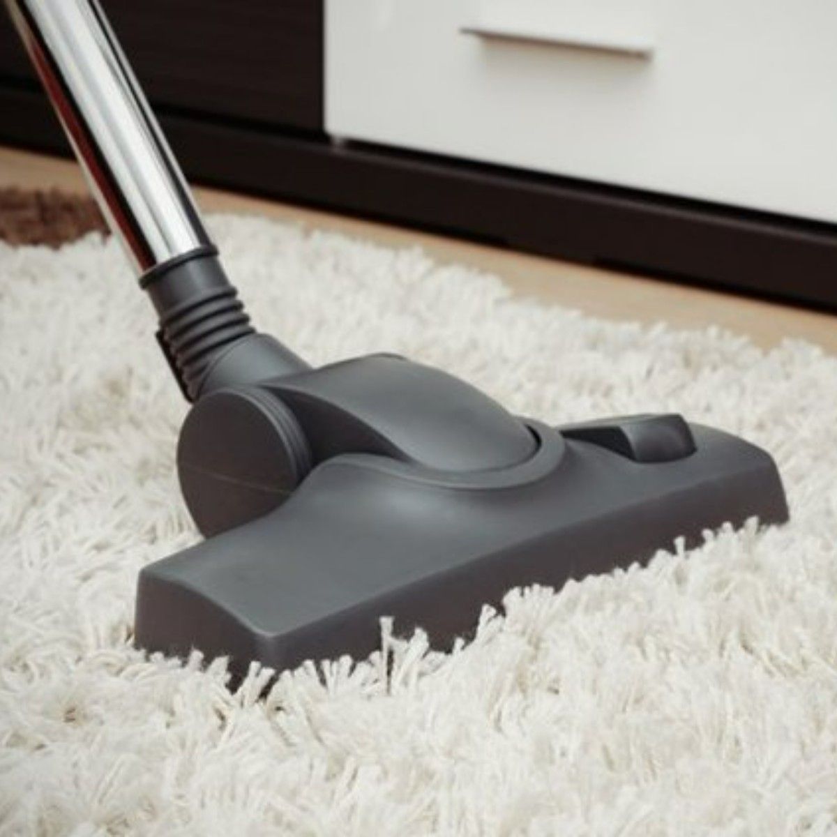 a vacuum cleaner is being used to clean a white carpet