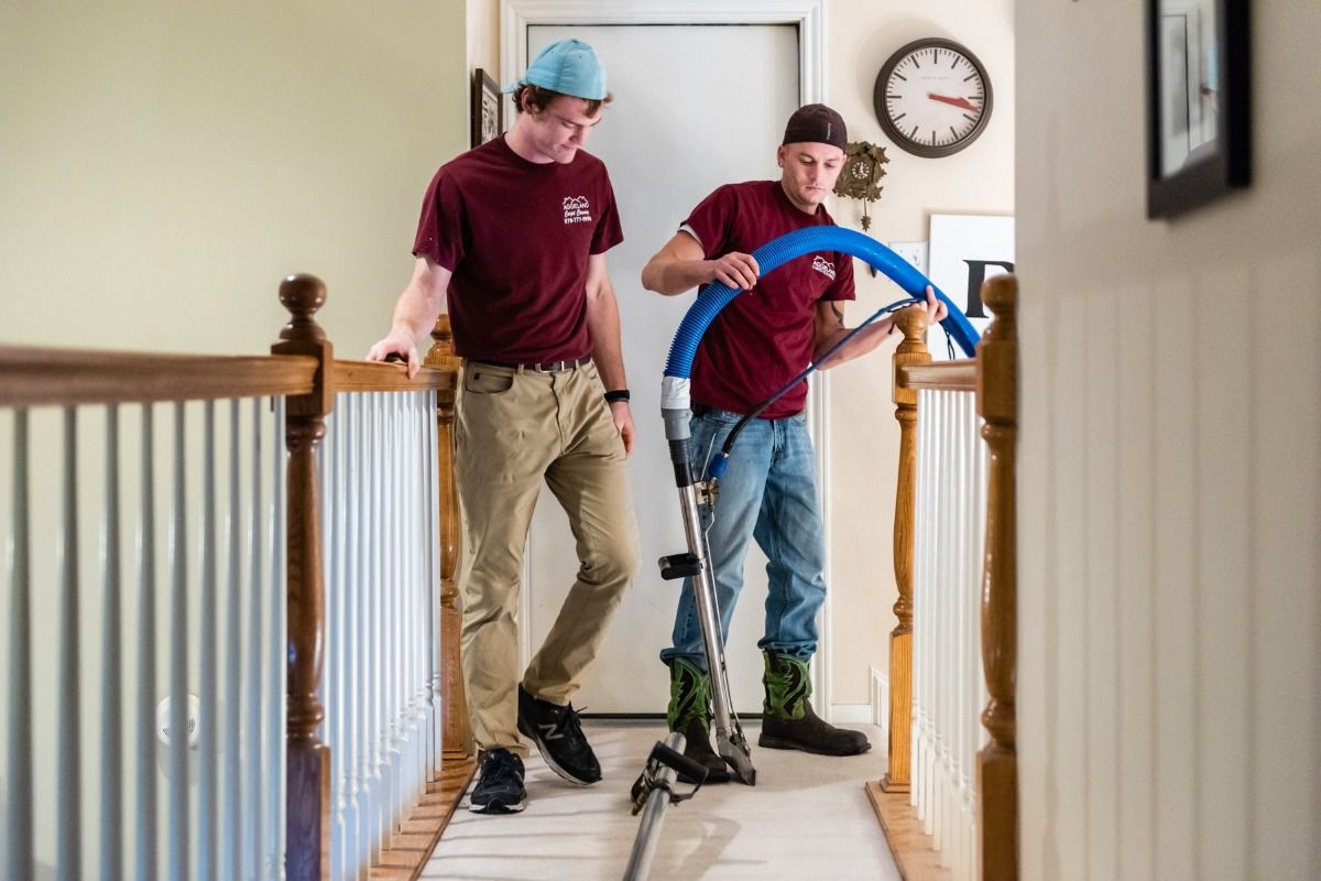 Aggieland Carpet Cleaning team performing hallway carpet cleaning with truck-mounted system