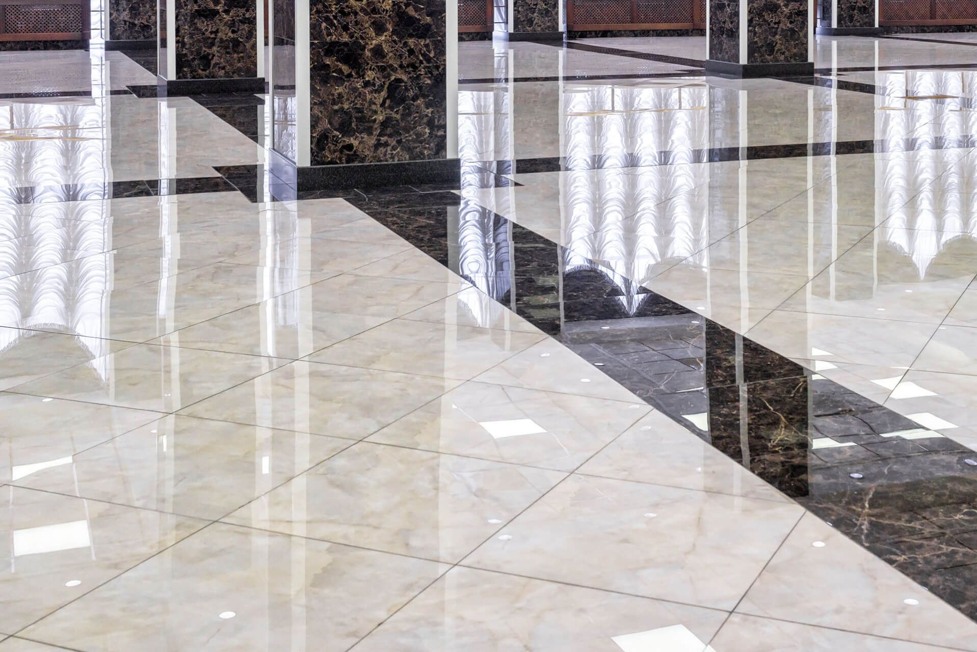 a large room with a marble floor and columns .