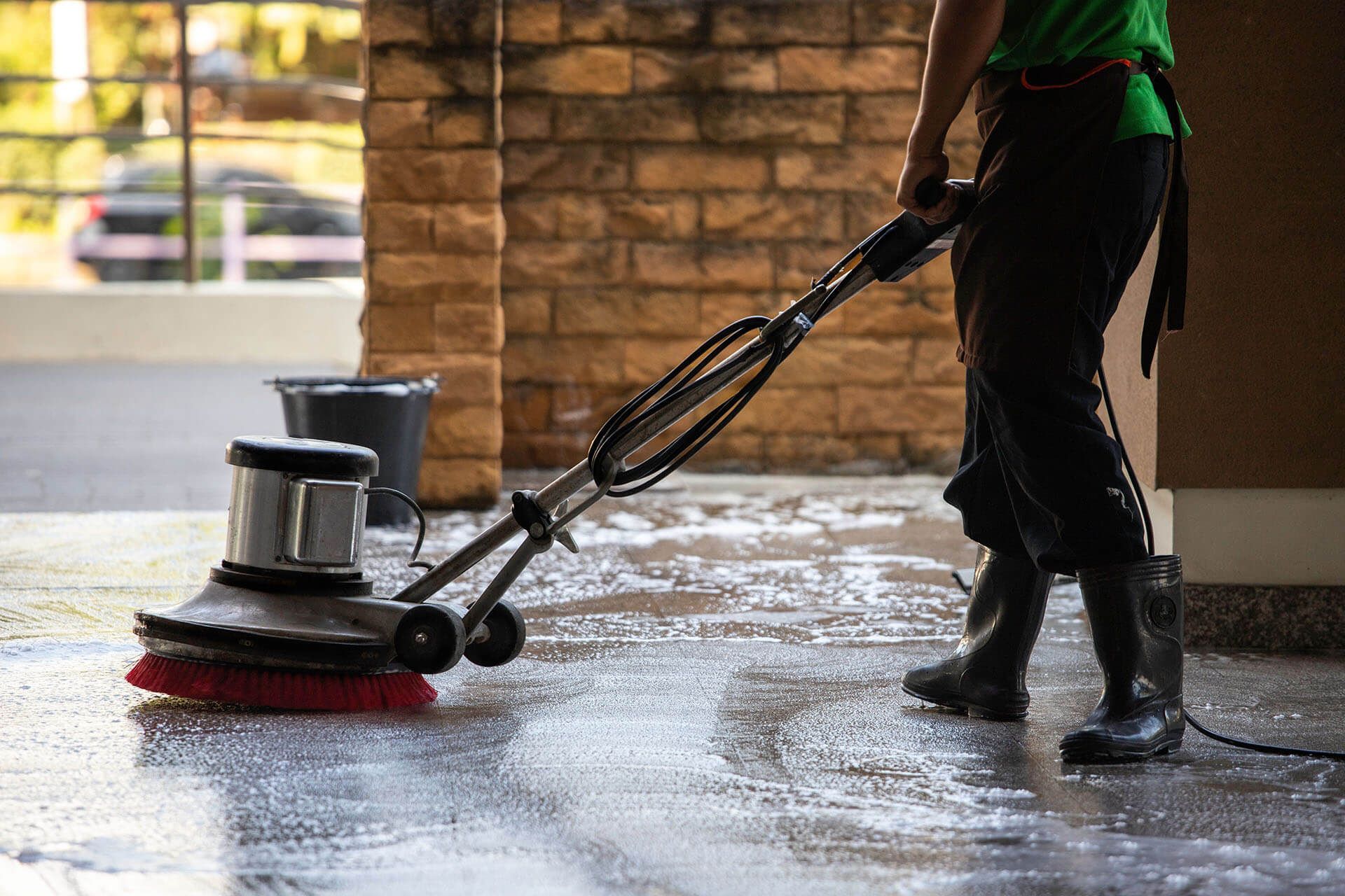 a man is cleaning the floor with a floor scrubber machine .