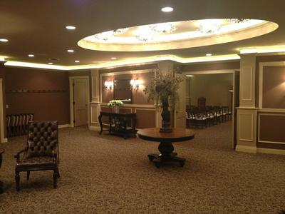 Elegant hotel lobby with patterned carpet, upholstered chairs, and a round ceiling light fixture