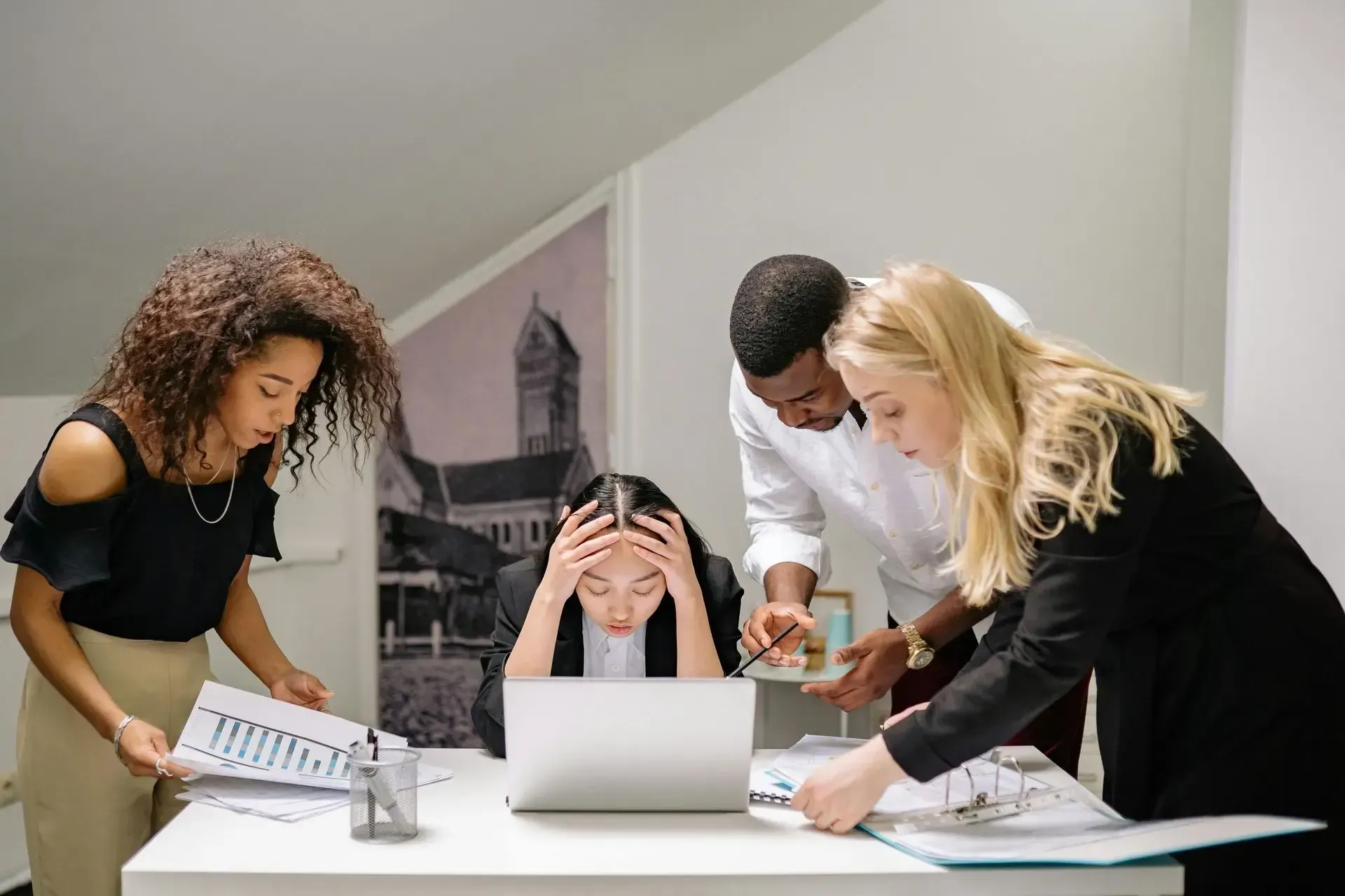 4 work members stressed out over a collaborative table at work