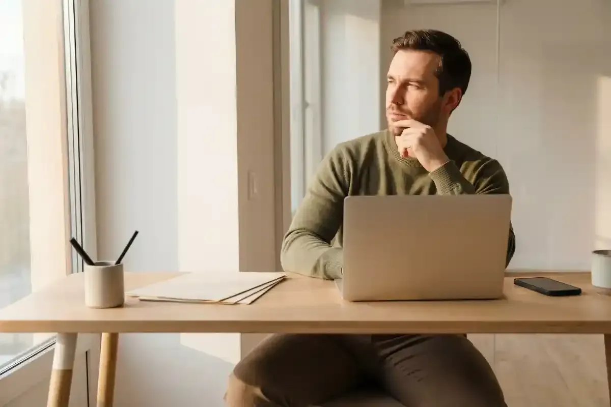 Man at his computer thinking.