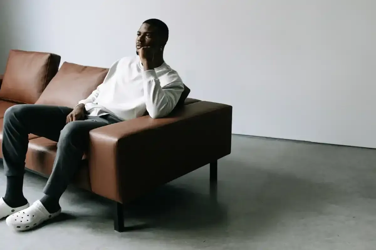 Man sitting on a couch thinking.
