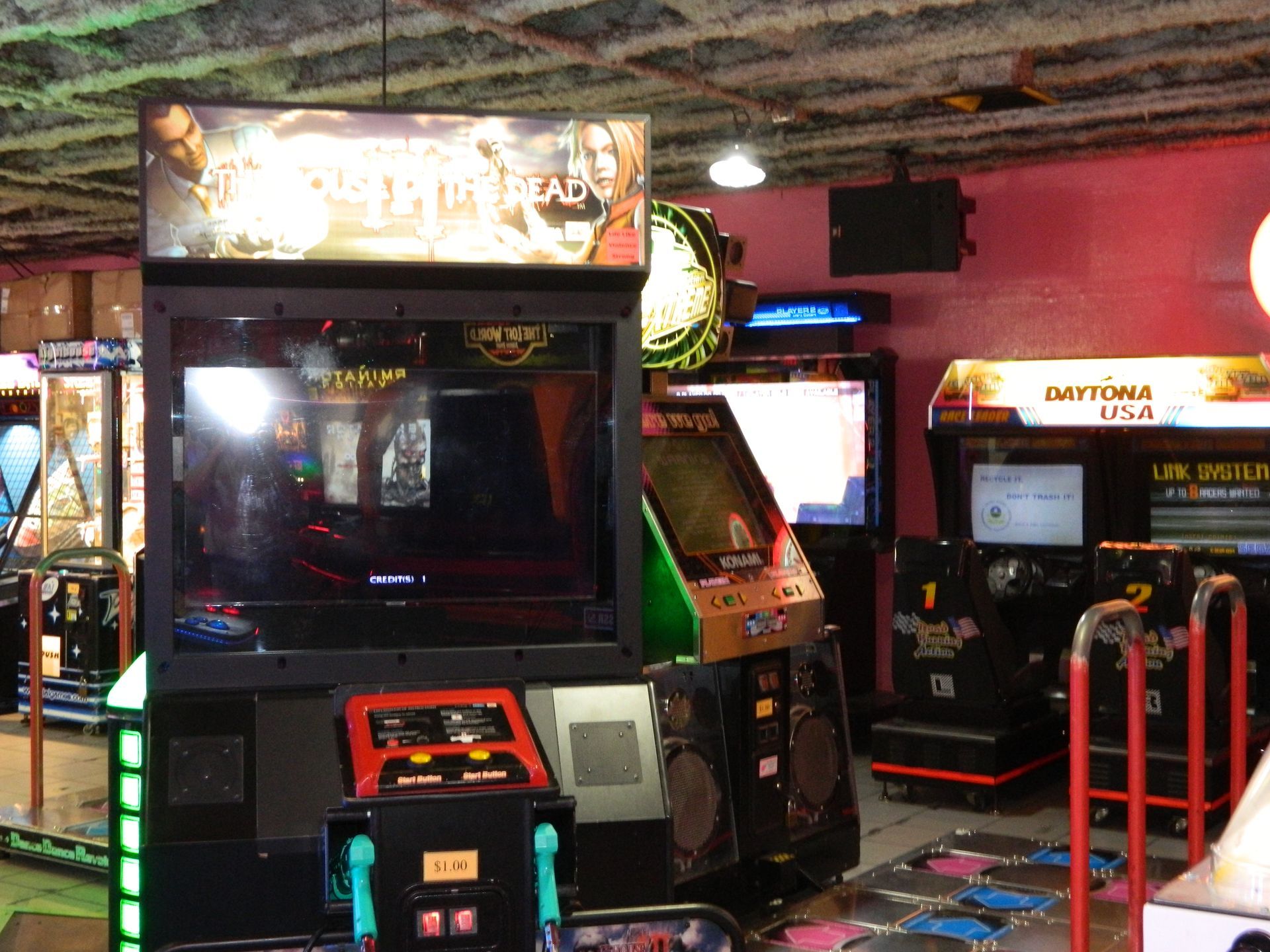 Arcade game featuring a large screen, control panel, and decorative cabinet. Surrounded by other arcade machines.