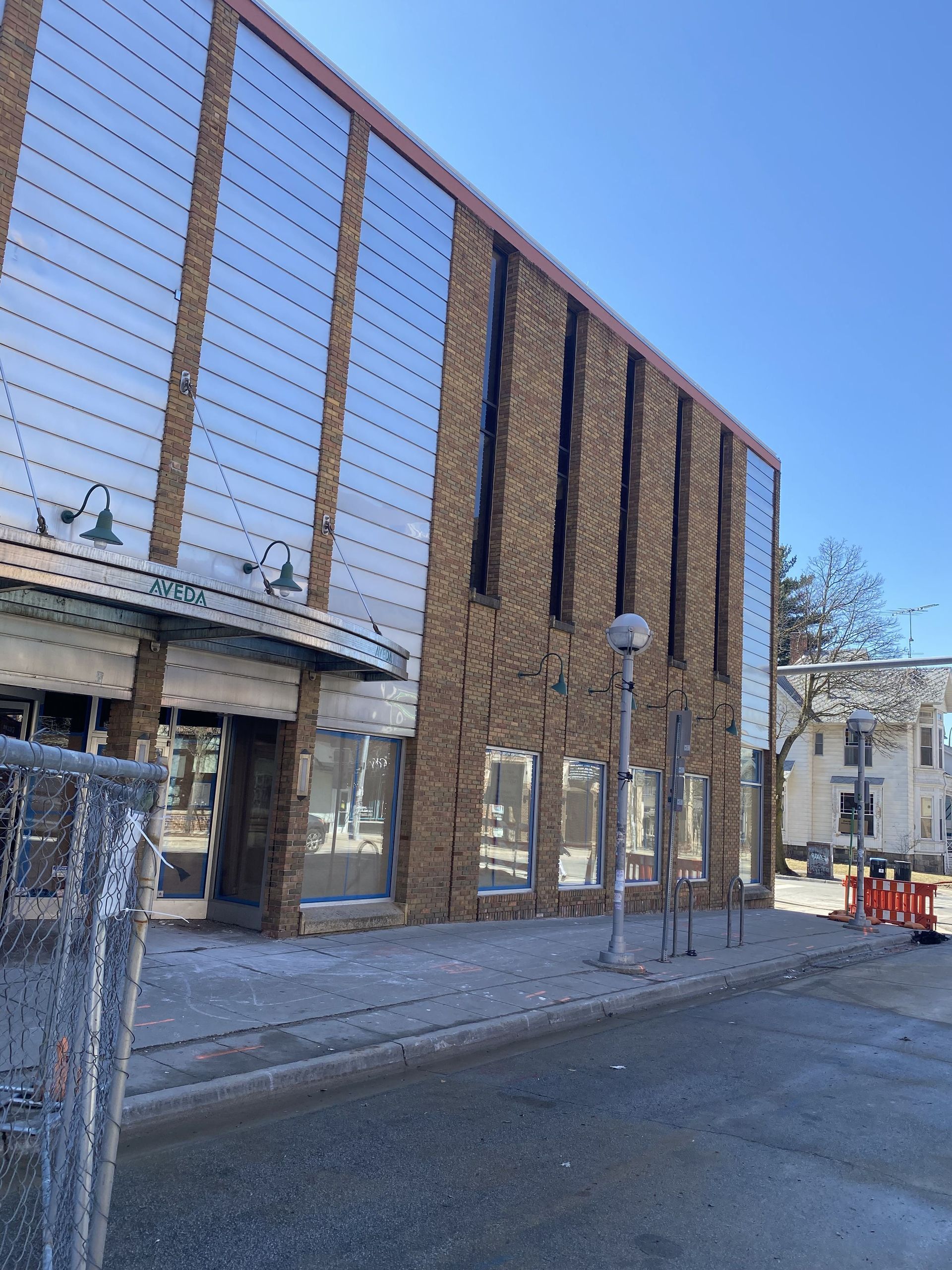 Building with mirrored panels and brick facade on a sunny day.