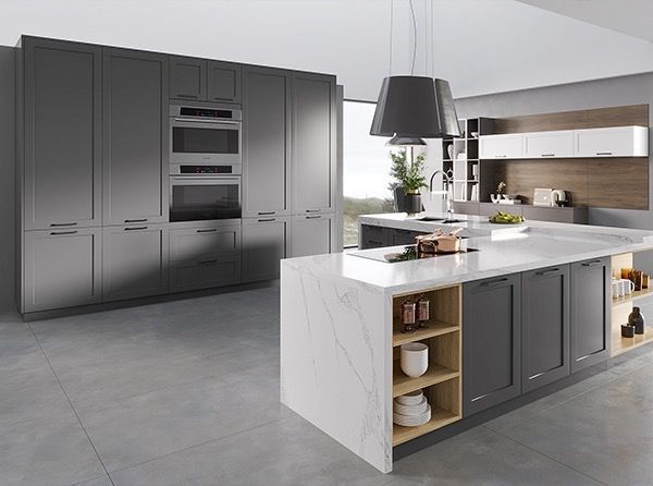 Modern kitchen with gray cabinets, white countertop island, and built-in appliances.