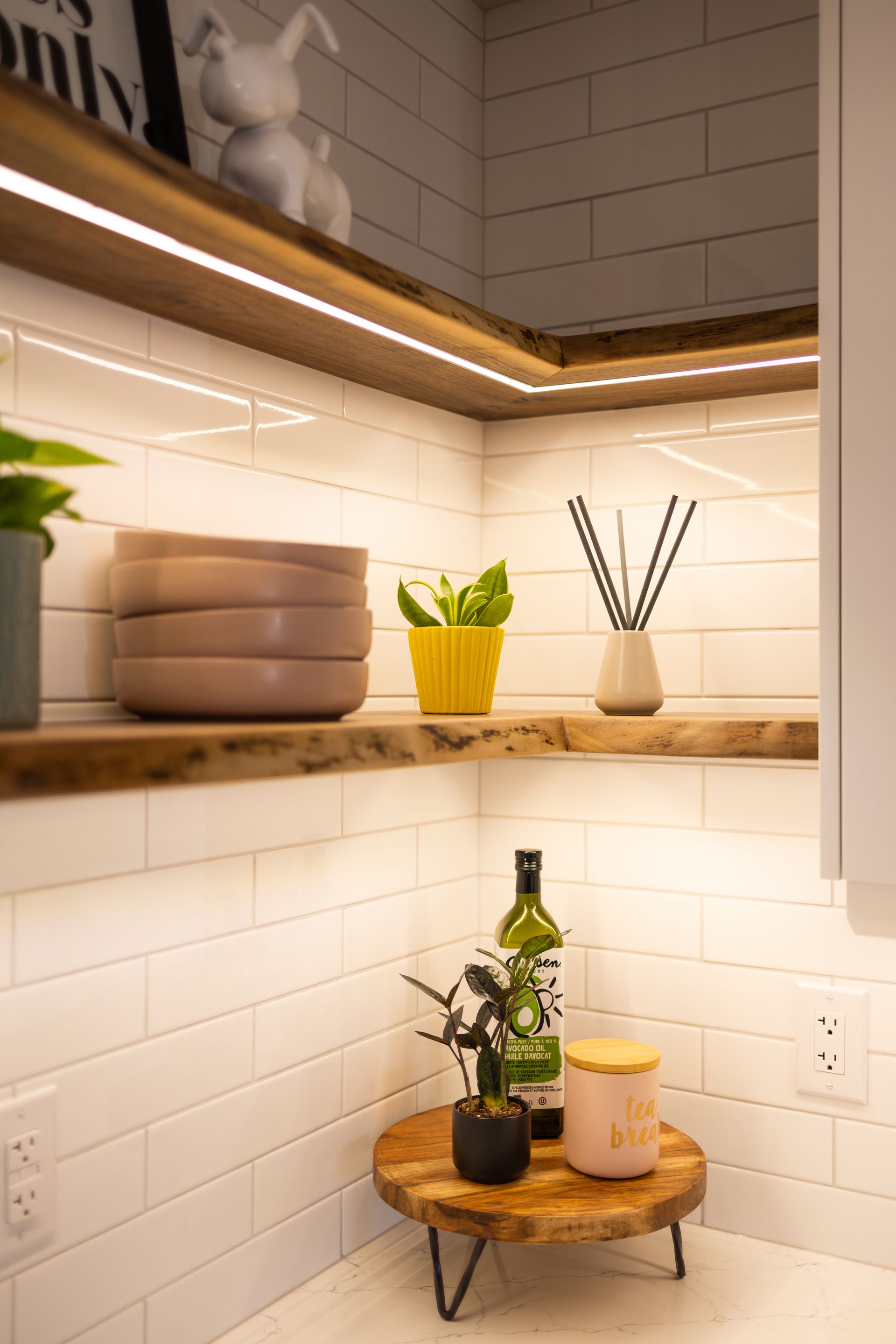 A kitchen with a wooden shelf and a bottle of wine on it.