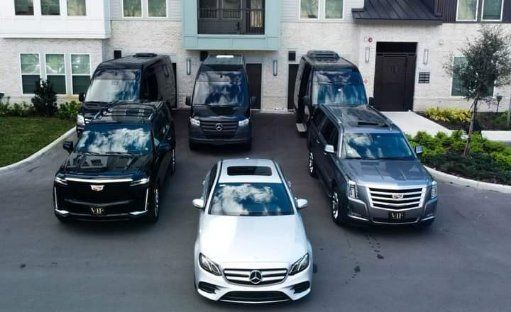 A group of cars are parked in front of a house.