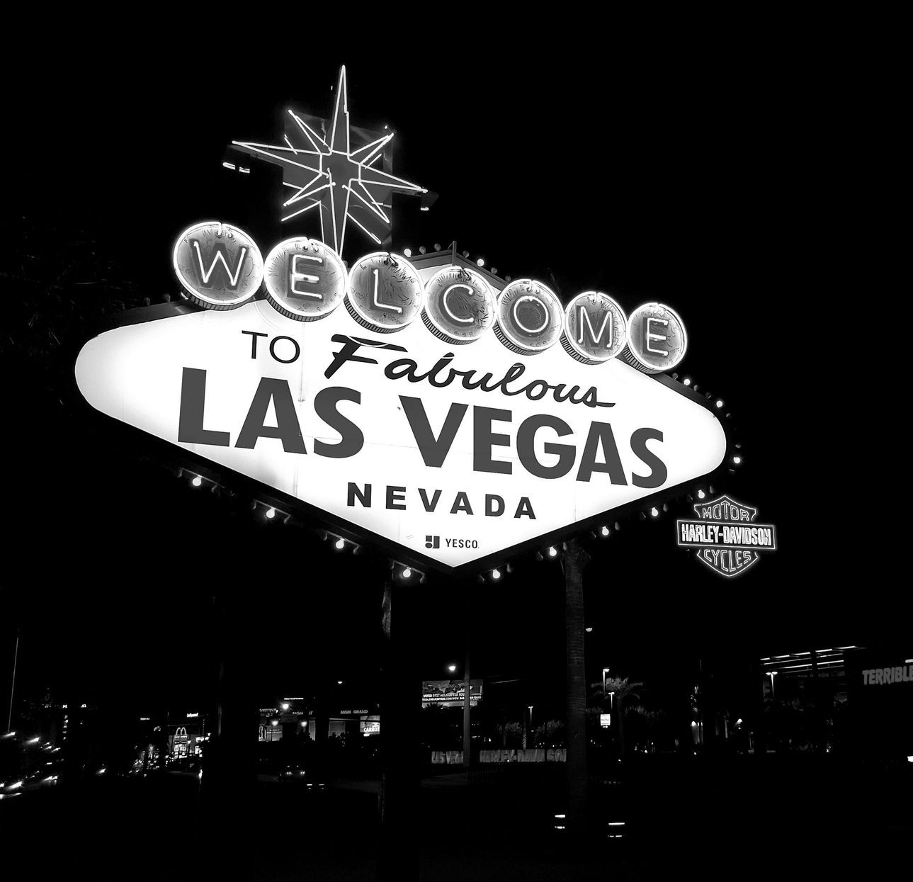 A black and white photo of a las vegas sign at night.