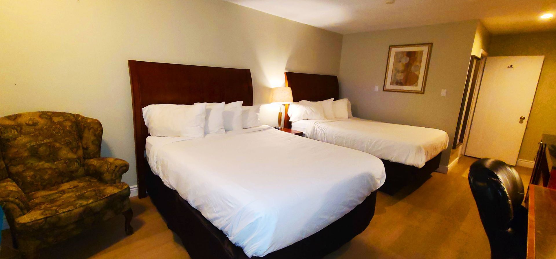 a hotel room with two beds and a chair .