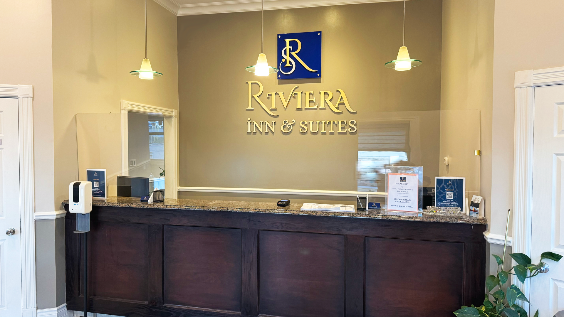 Hotel Riviera Inn & Suites reception desk with a logo 