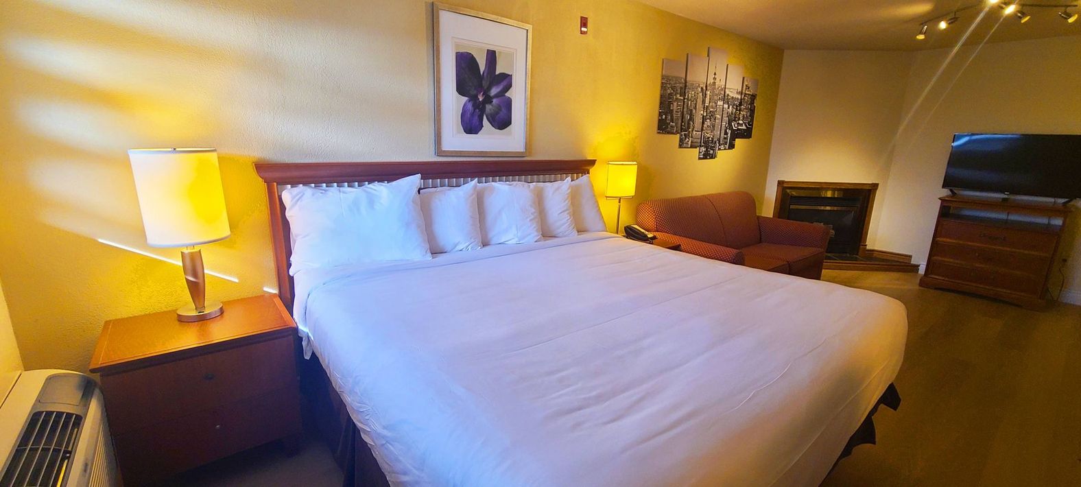 a hotel room with a king size bed and a fireplace .