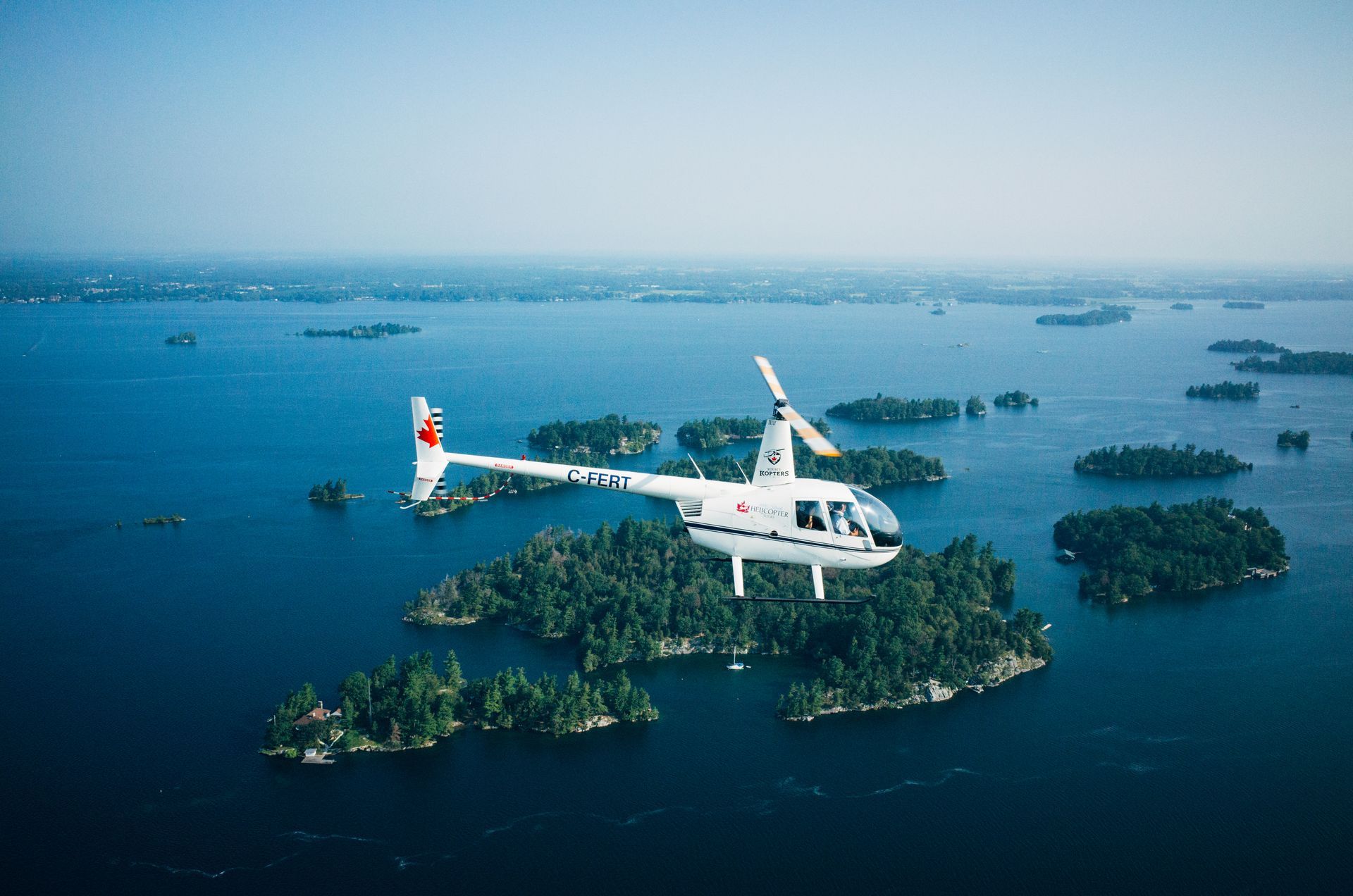 a helicopter is flying over a body of water surrounded by islands .