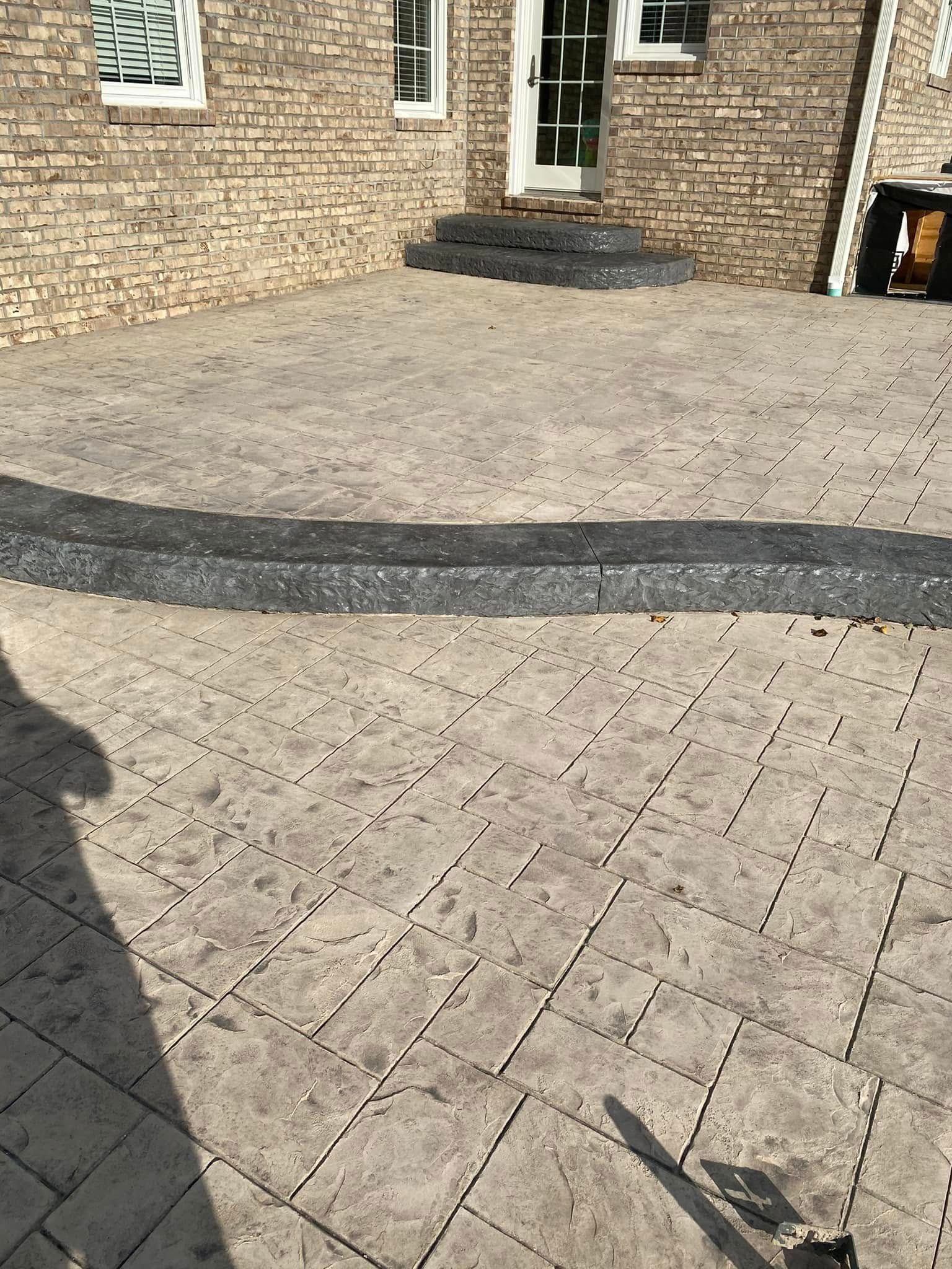 Brick-paved courtyard with a stone house entrance and low steps in the background