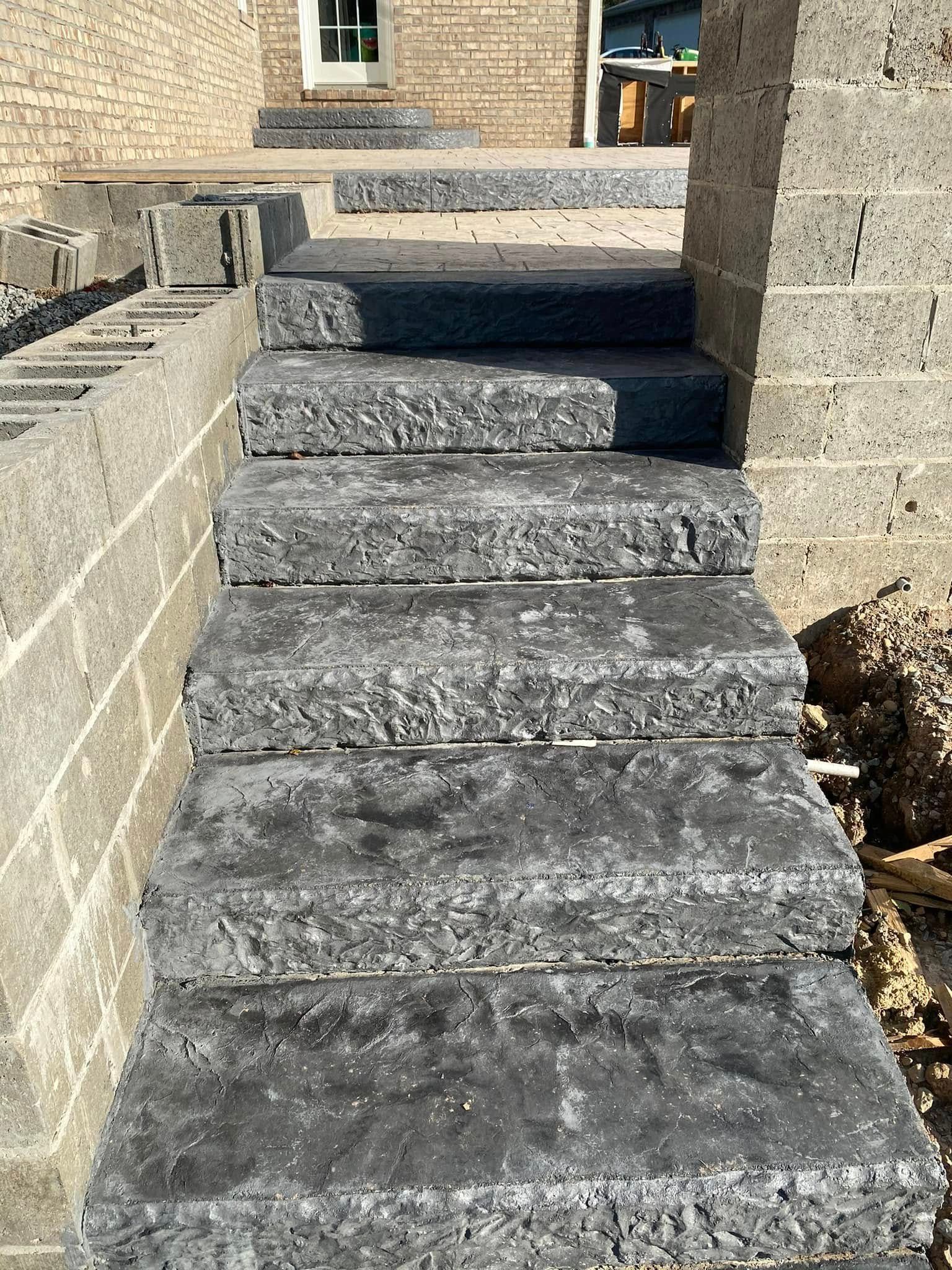 Stone steps leading up between two masonry walls to a building entrance.