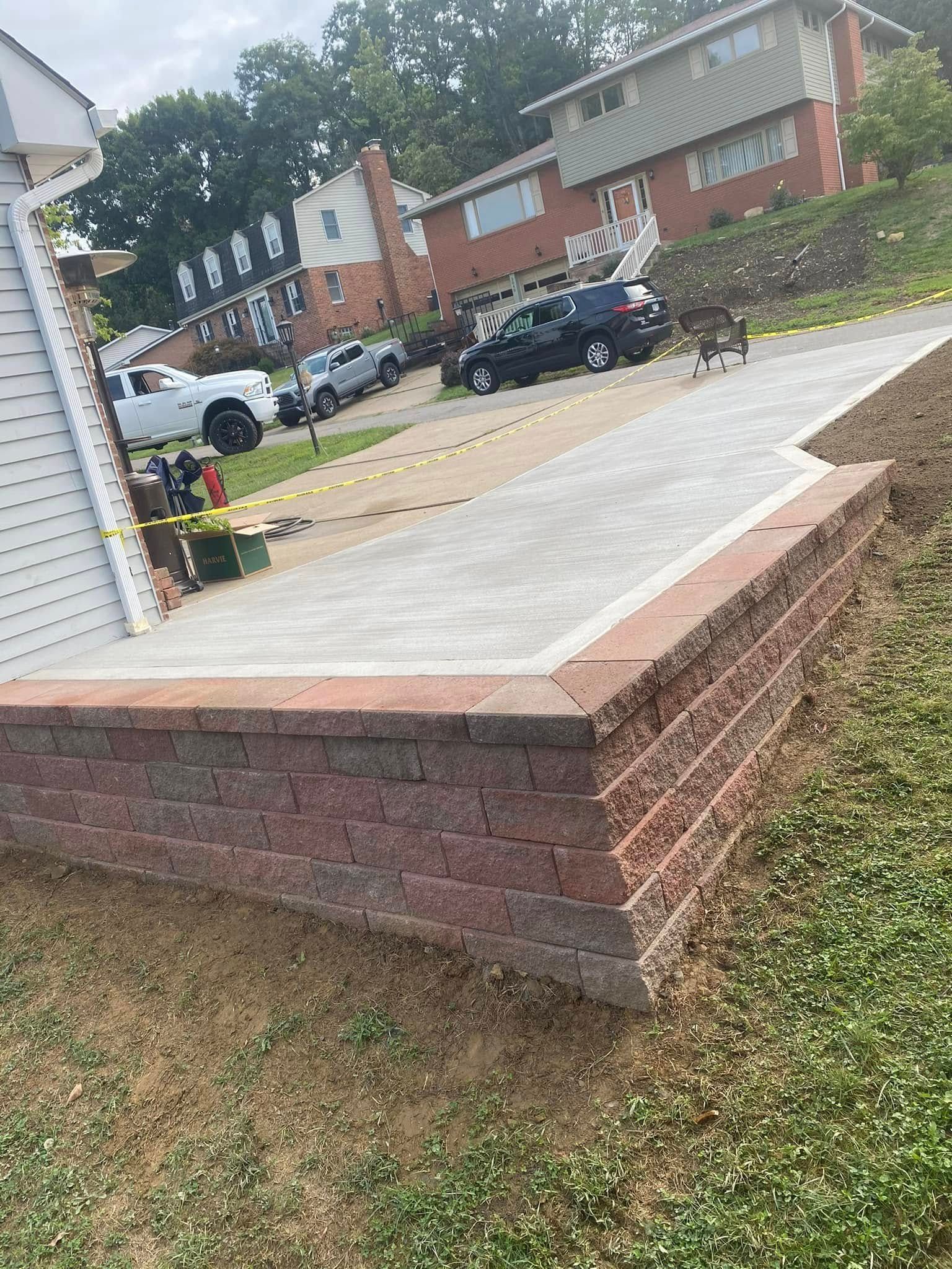 Brick front porch ramp leading to a suburban street with parked cars and apartment buildings